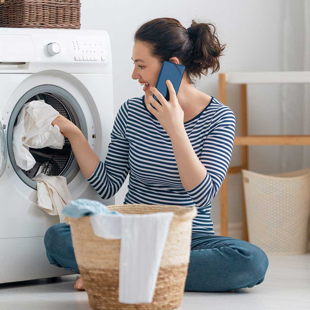 woman putting clothes in dryer